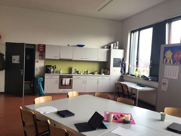 Raum mit K&uuml;chenzeile und Tischen